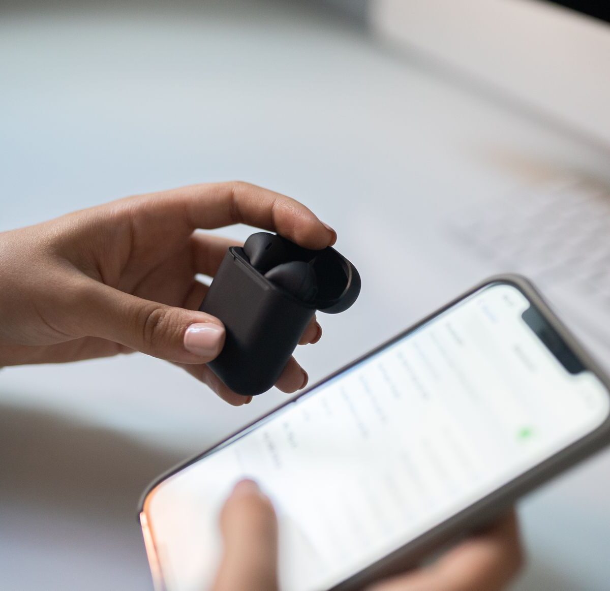 Listener connecting wireless earbuds to a smartphone music app
